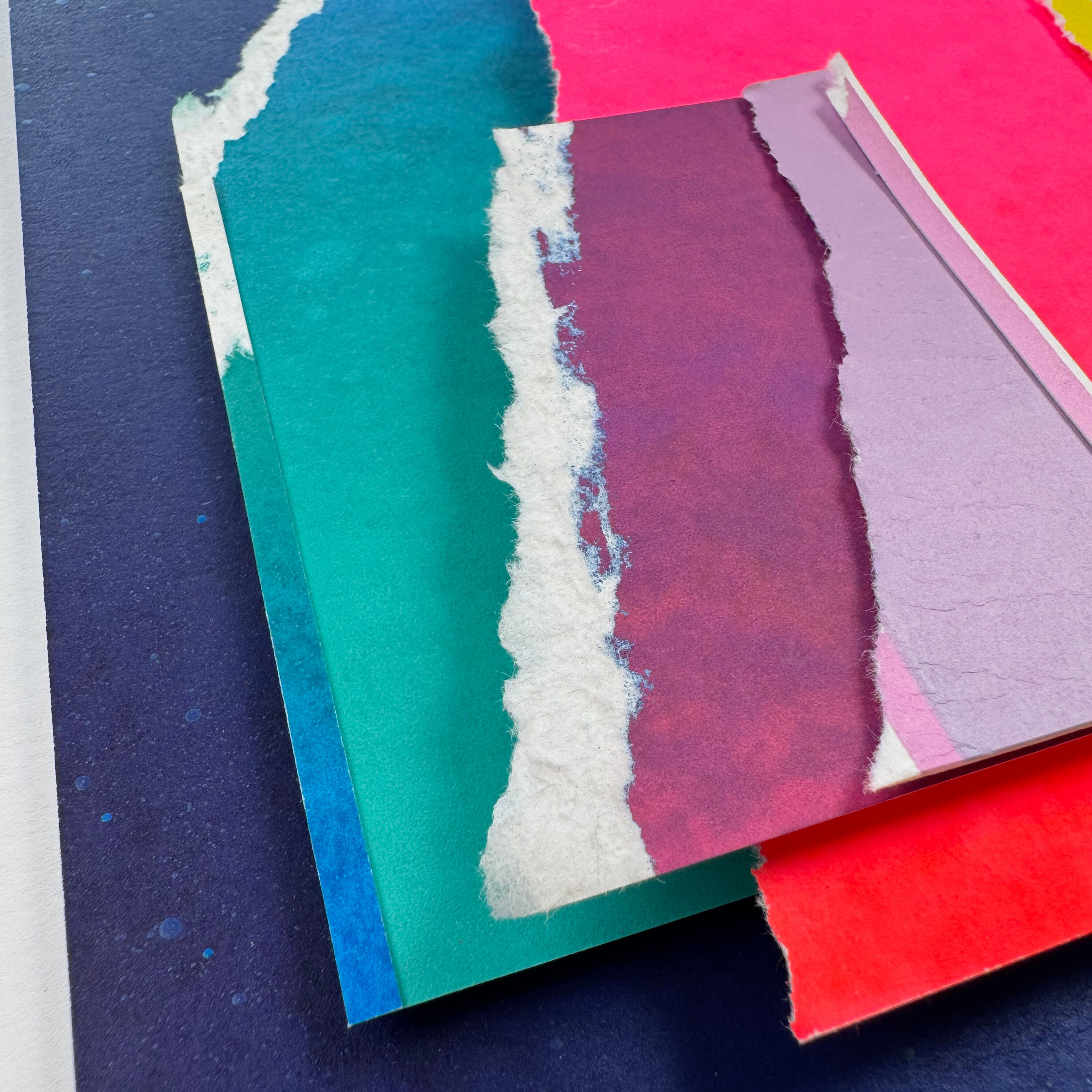 Mehrschichtige, abstrakte Collage aus gerissenem Papier in kräftigen Farben wie Blau, Türkis, Pink, Rot und Weiß. Die künstlerische Komposition wirkt modern und ist als dekoratives Unikat besonders für Kunstliebhaber geeignet.