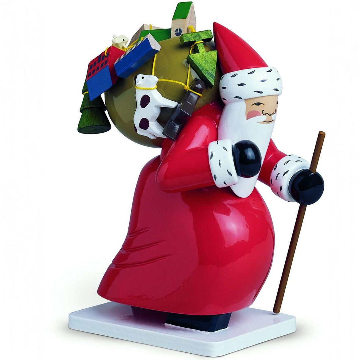 Freigestellte Holzfigur „Großer Weihnachtsmann mit Spielzeug“ von Wendt & Kühn: Ein rundlicher Weihnachtsmann im glänzend roten Mantel und Zipfelmütze trägt einen großen Sack mit buntem Spielzeug. Er hält einen braunen Stab; schwarzhandschuhige Hände, weißer Bart und weißes Fell mit schwarzen Tupfen ergänzen die Figur auf weißem Sockel.