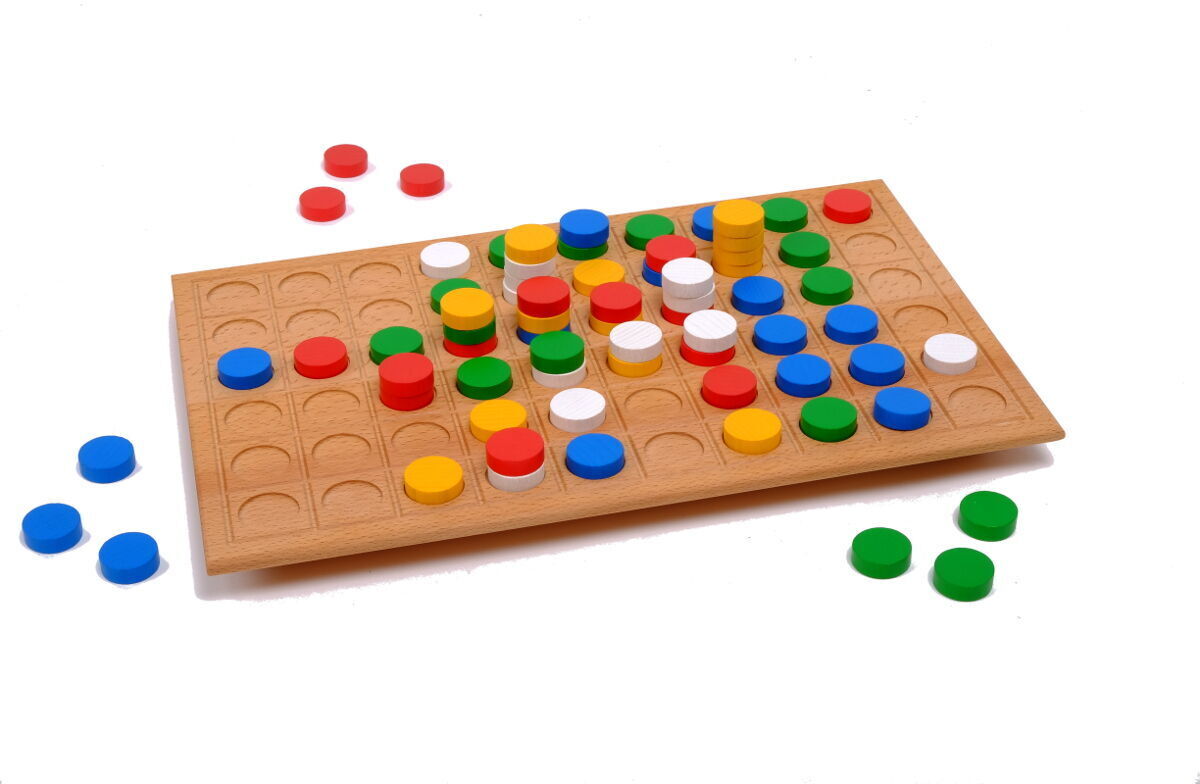 Das Bild zeigt das Spiel 'Quatro Flash', ein Brettspiel aus Holz mit bunten, runden Chips in Rot, Blau, Grün, Gelb und Weiß, die auf einem hölzernen Spielbrett verteilt sind.