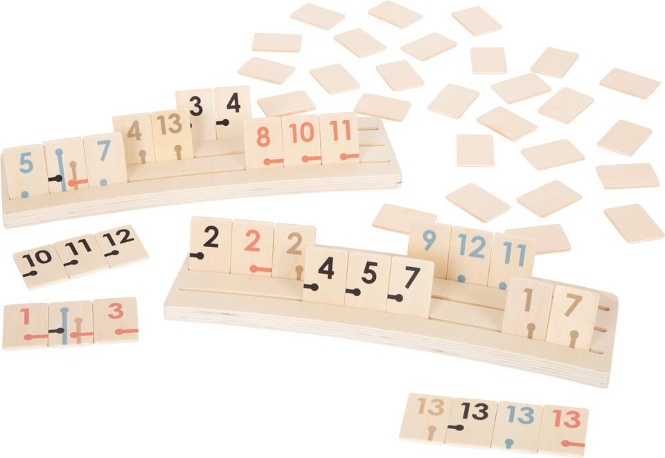 Das Bild zeigt das Rummy »Gold Edition« Spiel, bestehend aus Holzplättchen mit aufgedruckten Zahlen und farbigen Markierungen. Die Spielsteine sind auf zwei Holzbrettern aufgereiht und liegen teilweise verstreut auf dem Tisch. Geeignet für Kinder und Erwachsene für Spielabende und Familienfeiern.