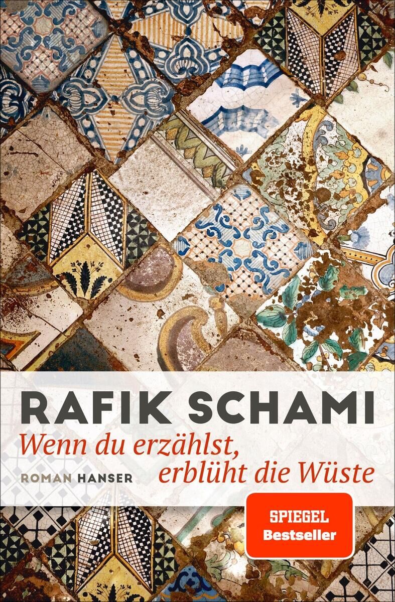 Buchcover des Romans 'Wenn du erzählst, erblüht die Wüste' von Rafik Schami. Das Cover zeigt ein buntes orientalisches Mosaikmuster in verschiedenen Farben wie Beige, Blau, Braun, Orange und Weiß. Oben steht der Autorname 'Rafik Schami' in roten Großbuchstaben, darunter der Untertitel 'Wenn du erzählst, erblüht die Wüste' in rot und grau.