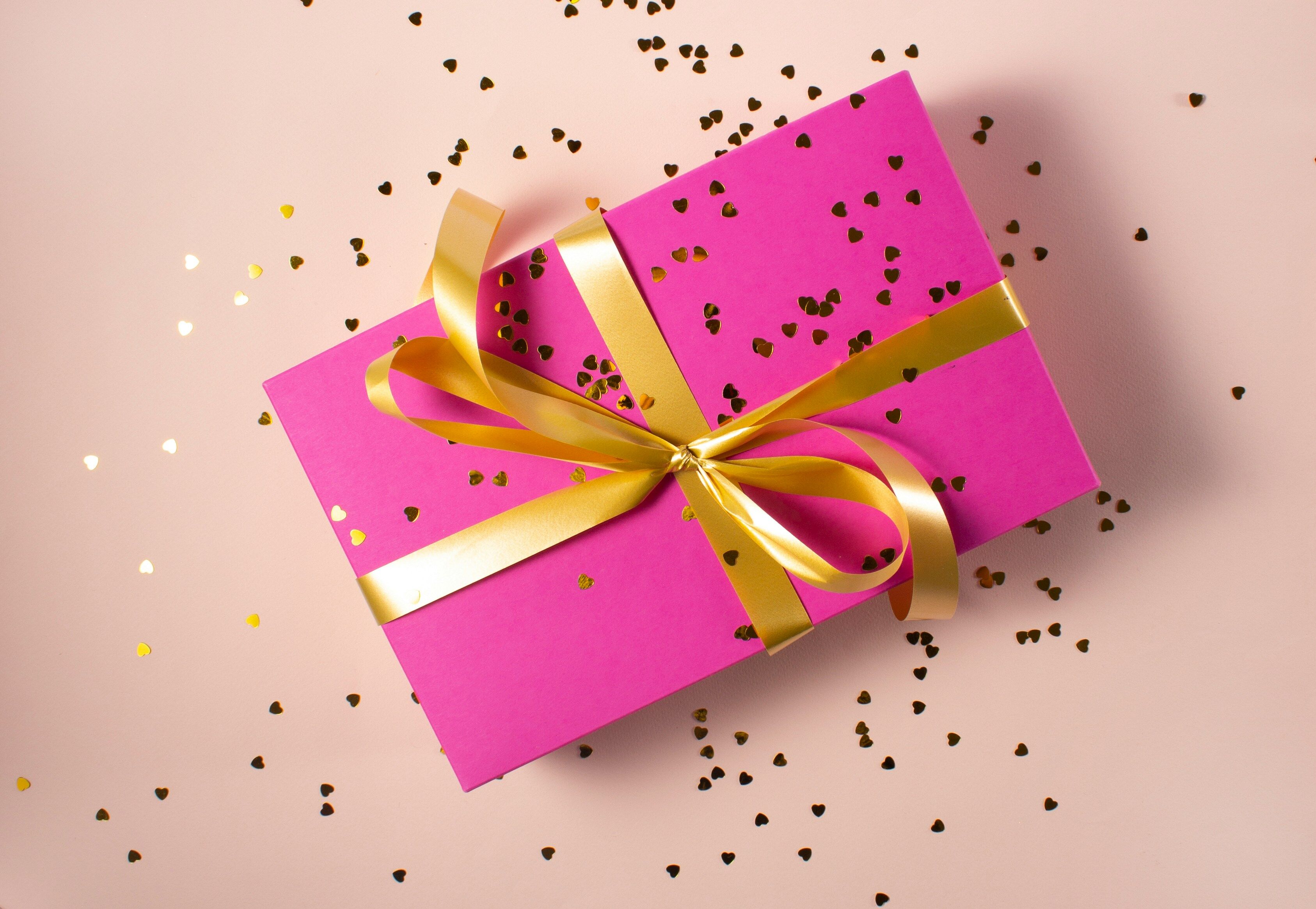 alt="Ein eingepacktes Geschenk mit Schleife und Konfetti, das die Kategorie Geschenkbücher darstellt"