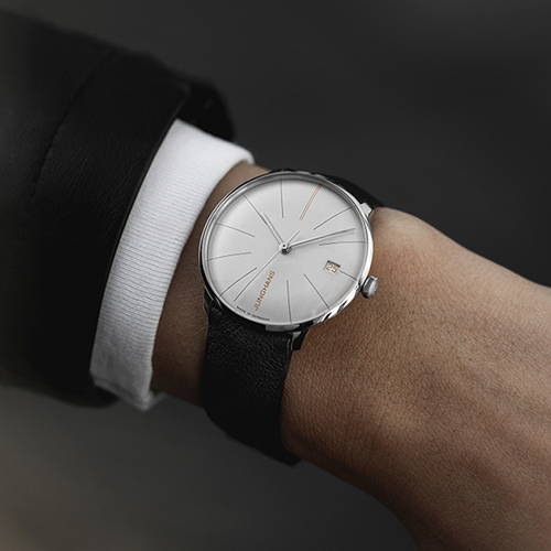 Elegante Junghans Armbanduhr mit silbernem Zifferblatt, schwarzem Lederarmband und Datumsanzeige am Handgelenk