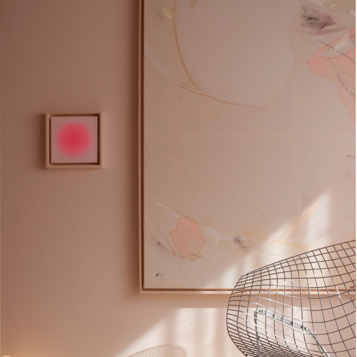Gerahmtes Kunstbild ZEIT-Sonderedition Sorbet »Pink« (20x20cm) an einer pastellrosafarbenen Wand, flankiert von einem großen abstrakten Gemälde, Metallstuhl und flauschigem Teppich im weichen Sonnenlicht, modernes und minimalistisches Interieur.