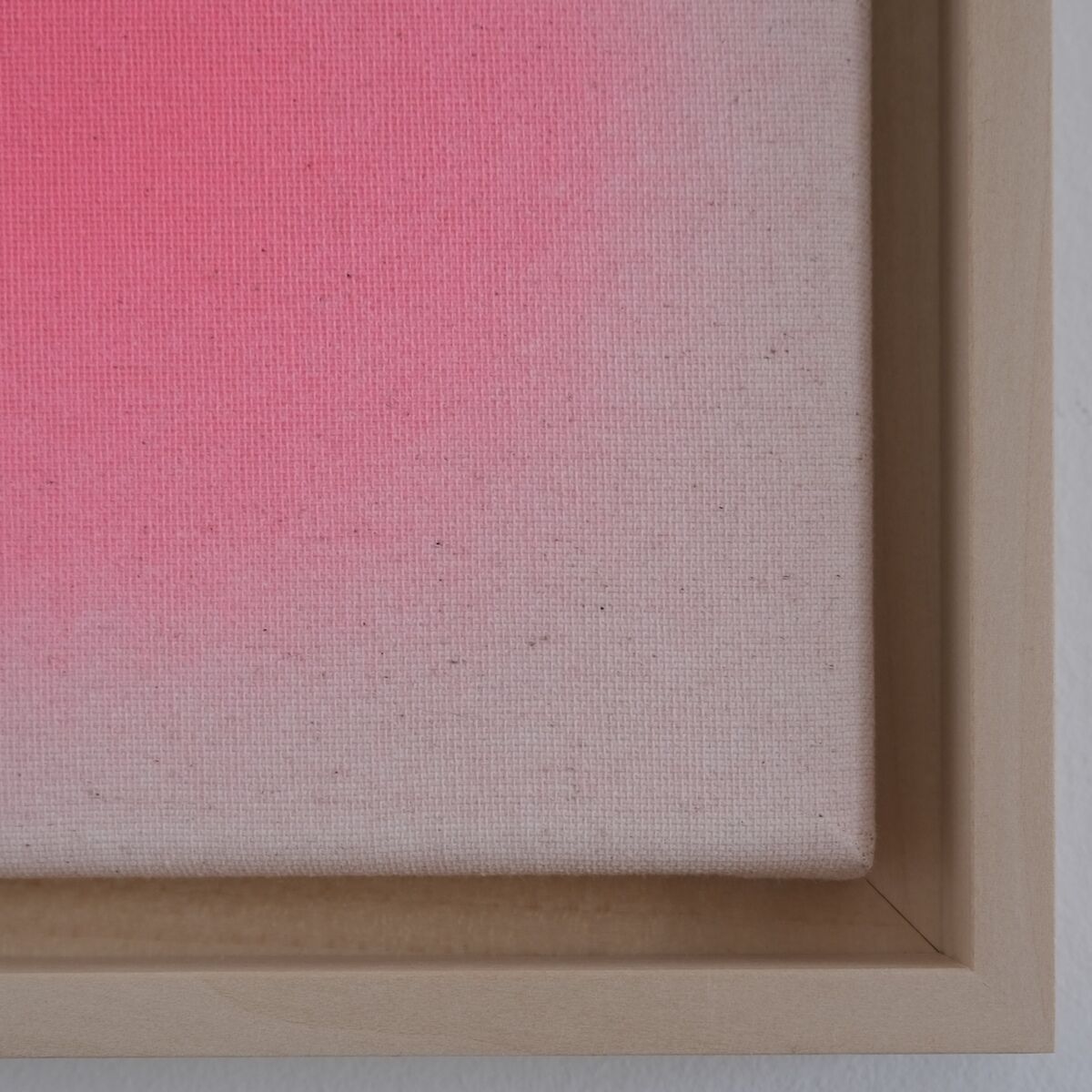 Quadratisches Kunstwerk der ZEIT-Sonderedition Sorbet »Pink« in einer Größe von 20x20 cm. Das Bild zeigt einen sanften Farbverlauf von kräftigem Pink zu zartem Hellrosa auf texturierter Leinwand, eingefasst in einem schmalen, hellen Holzrahmen. Das Werk hängt an einer weißen Wand und besticht durch minimalistisches, modernes Design.