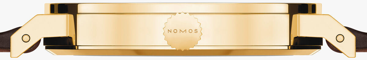 Seitenansicht der NOMOS ZEITmagazin-Sonderedition Tangente Gold neomatik 38 Update: flaches, rundes Gehäuse aus poliertem 18-karätigem Gold mit geprägtem NOMOS-Logo, edles dunkelbraunes Horween-Lederarmband, minimalistisch, luxuriös, auf weißem Hintergrund.