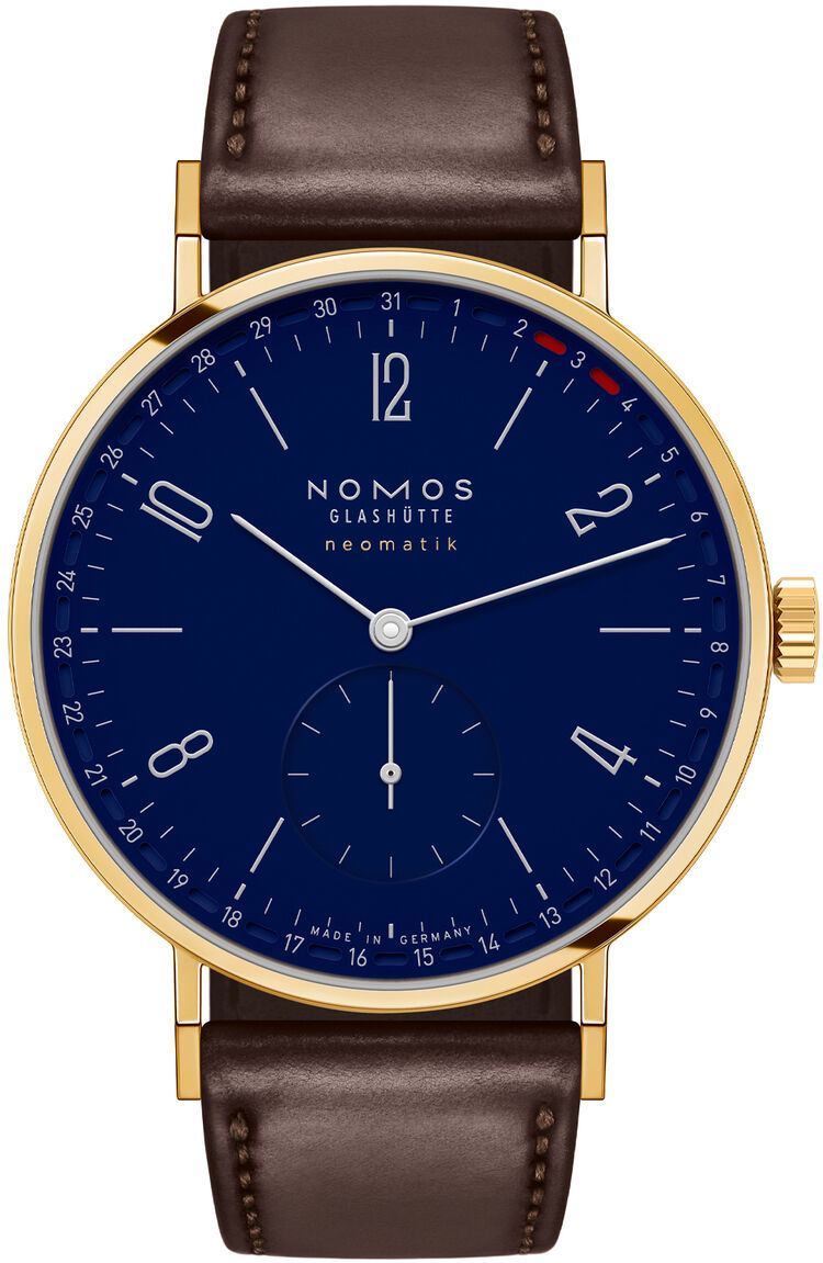 ZEITmagazin-Sonderedition Tangente Gold neomatik 38 Update von NOMOS: Edle Armbanduhr mit 38 mm Gehäuse aus 18kt Gold, saphirblauem Zifferblatt und dunkelbraunem Lederarmband. Fein gearbeitete Zeiger, goldene Lünette, limitierte Edition, modernes und klassisches Design.