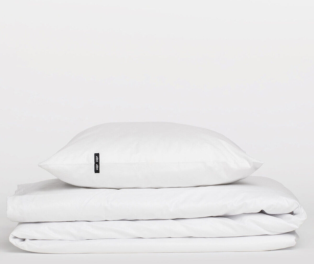 Weiße Bettwäsche »Pure« bestehend aus einem Kopfkissenbezug und einem Bettdeckenbezug, schlicht und minimalistisch auf einem weißen Hintergrund.