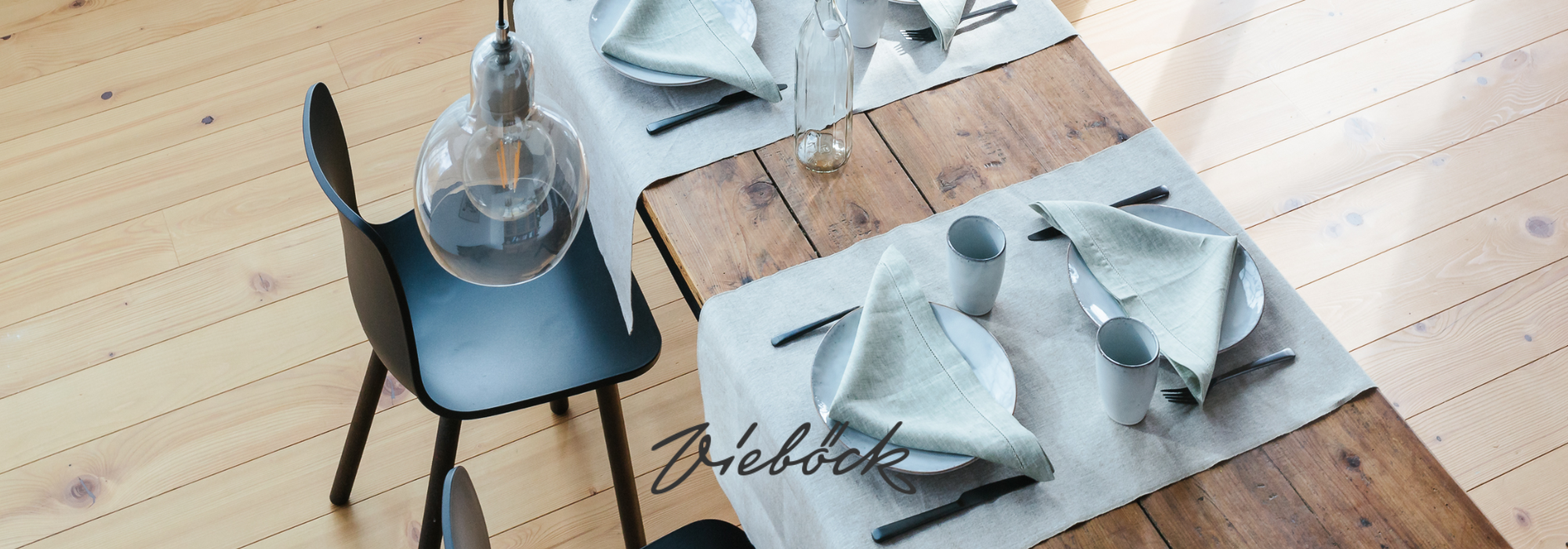Ein stilvolles Esszimmer mit hellen Leinenservietten, Tellern und Besteck auf einem Holztisch, begleitet von einer modernen Deckenleuchte.
