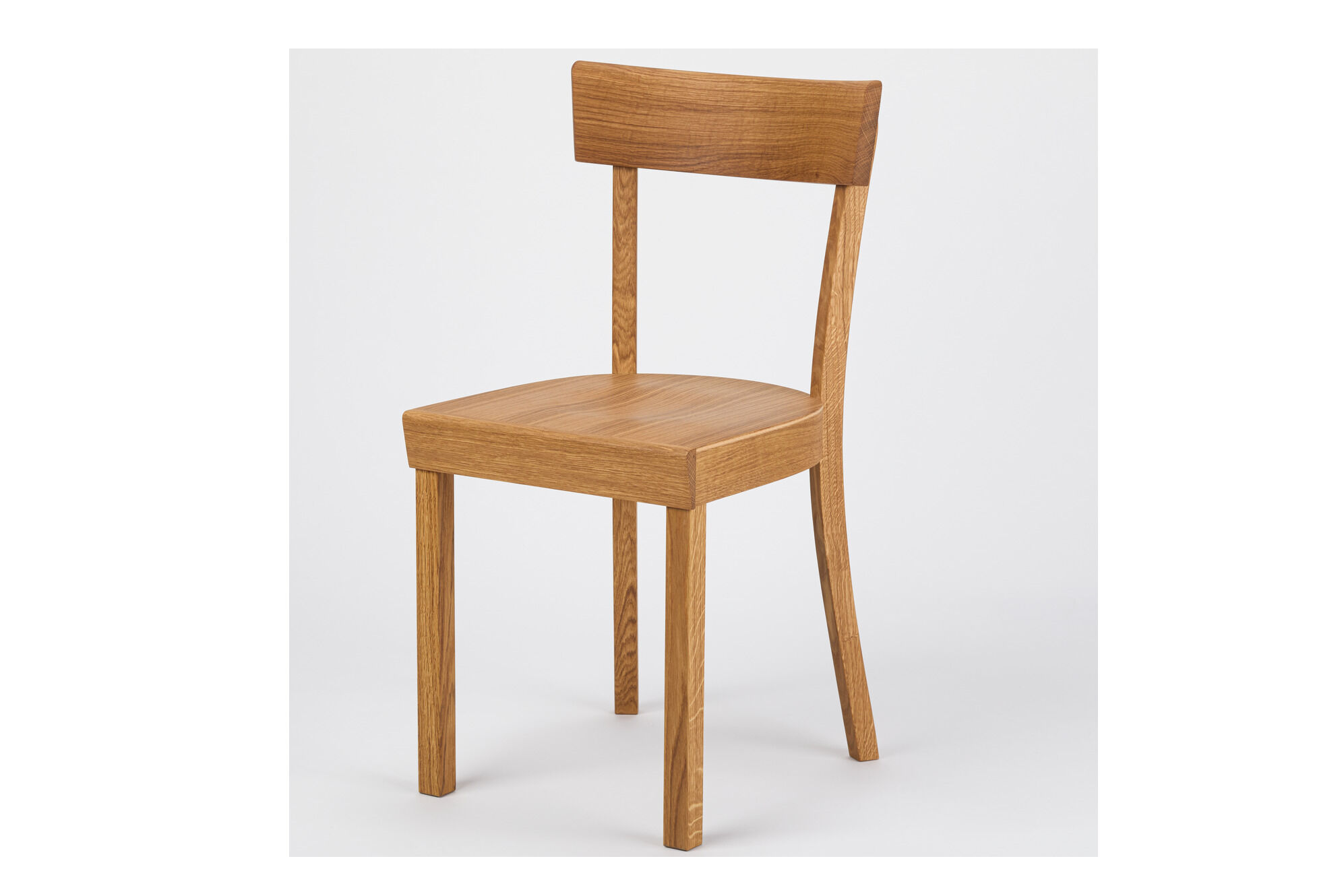 Ein schlichter Küchenstuhl aus geölter Eiche mit gerader Rückenlehne und klaren Linien steht vor neutralem, hellem Hintergrund. Der Stuhl kombiniert klassisches deutsches Design mit moderner Handwerkskunst.