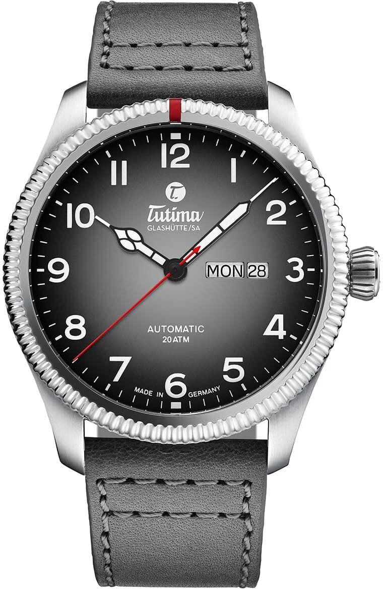Eine klassische Armbanduhr der ZEIT-Sonderedition »Grand Flieger Classic Automatic Schiefergrau« mit grauem Zifferblatt und Edelstahlgehäuse. Sie verfügt über ein graues Lederarmband und eine einfache, elegante Anzeige mit weißen und roten Akzenten.