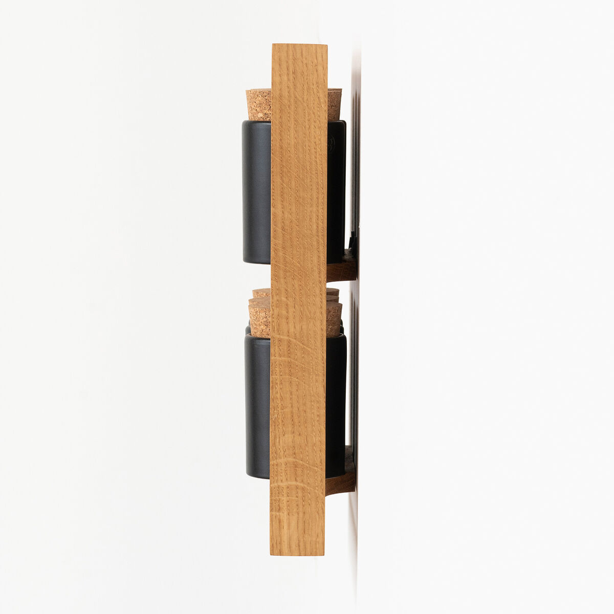 Ein minimalistisches Gewürzregal aus Holz zur Wandmontage mit schwarzen Behältern. Das Regal enthält zwei Schichten für Gewürzgläser. Das Design ist modern und platzsparend.