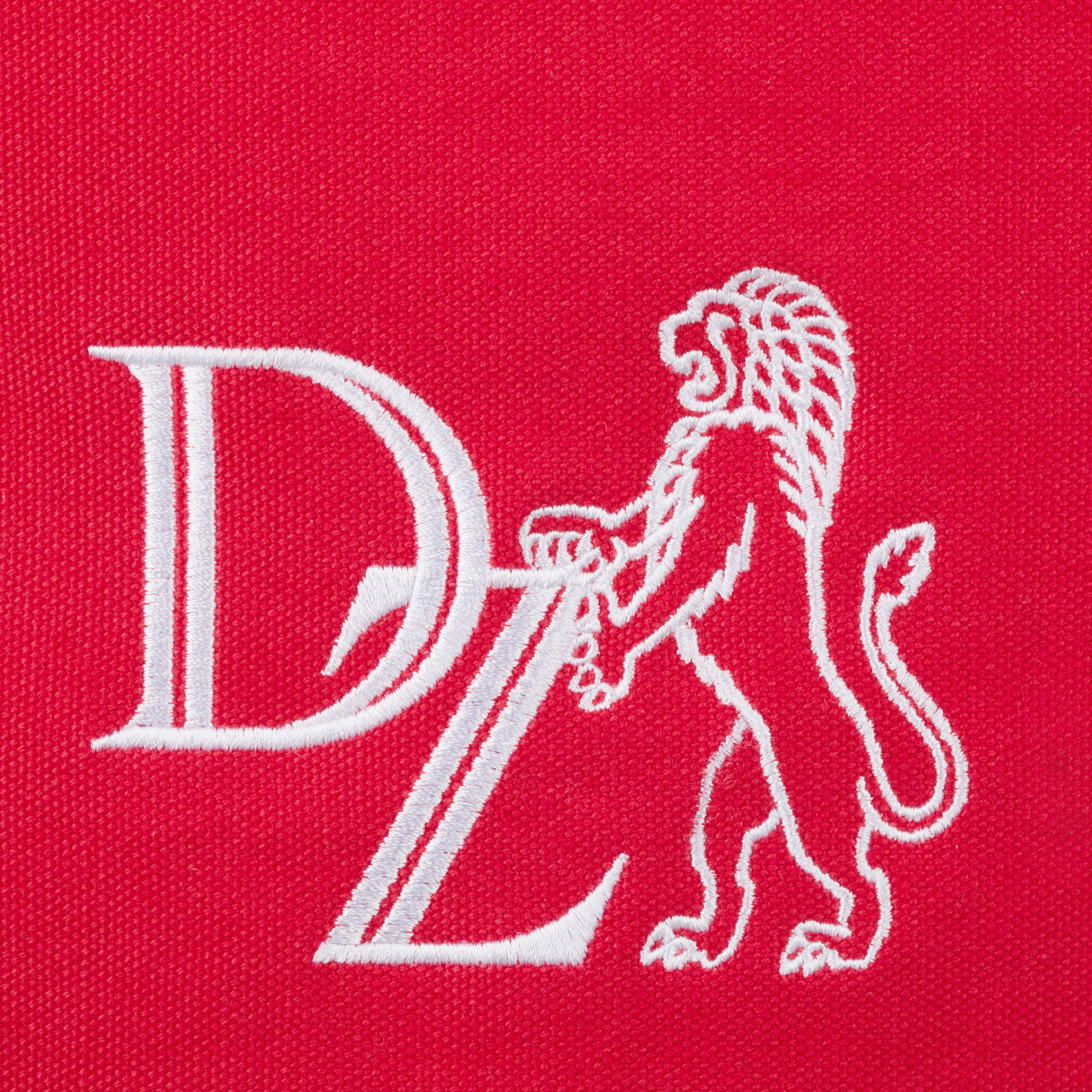 Canvas-Tasche in Korallenrot mit weißer Stickerei eines Löwenmotivs und den Buchstaben DZ.