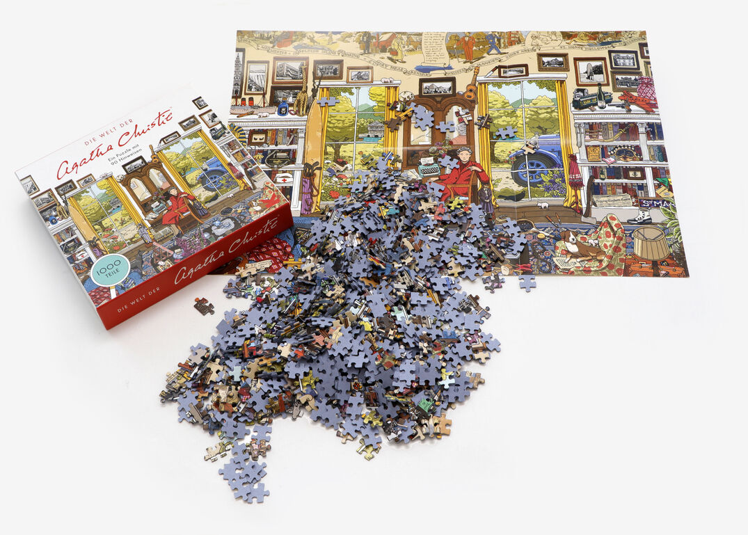 Ein Puzzle mit dem Motiv 'Die Welt der Agatha Christie' ist teils zusammengesetzt und zeigt eine viktorianische Detektivszene. Daneben liegt die Verpackung, die das fertige Bild zeigt sowie zahlreiche lose Puzzleteile.