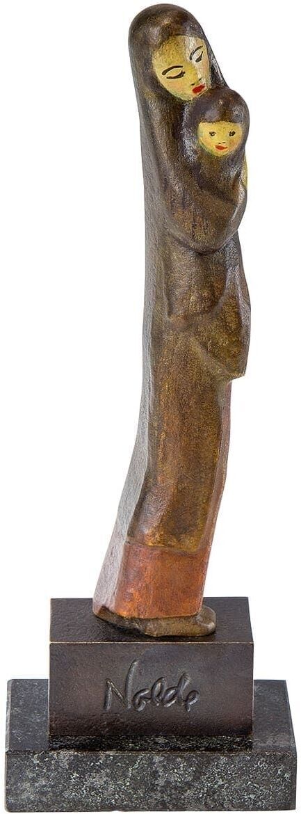 Eine Holzskulptur von Emil Nolde, die eine stehende Mutter zeigt, die ein Kind in den Armen hält. Die Skulptur ist auf einem Sockel befestigt und in warmen Brauntönen und Schwarz gehalten.