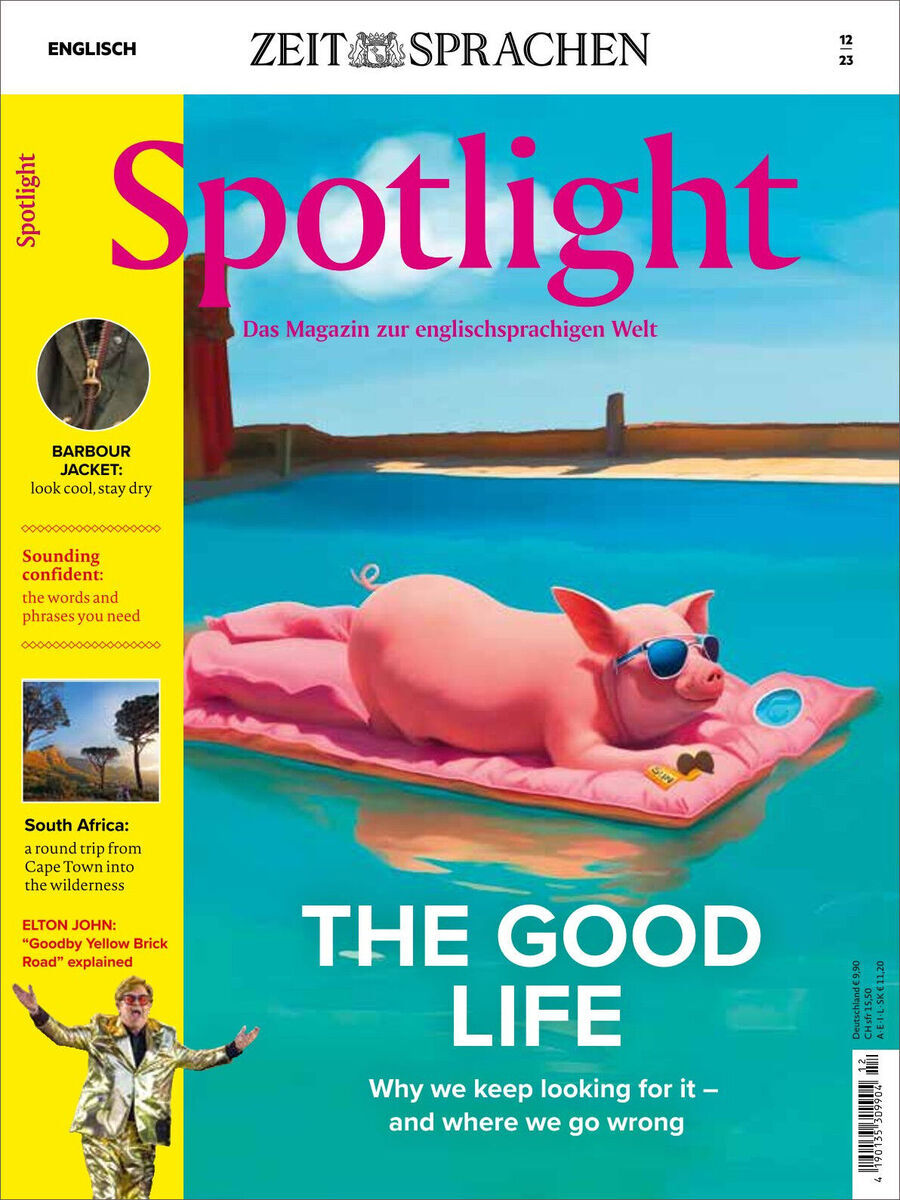 Das Titelbild des Spotlight Magazins vom Dezember 2023 zeigt ein Schwein, das auf einer rosa Schwimmliege im Wasser liegt. Der Hintergrund ist eine Meerlandschaft mit blauem Himmel. Der Titel des Magazins lautet 'Spotlight' in auffälligen rosa Buchstaben mit dem Deckensatz 'Das Magazin zur englischsprachigen Welt'. Weitere Highlight-Themen auf dem Cover sind 'Barbour Jacket', 'Südafrika' und 'Elton John'.