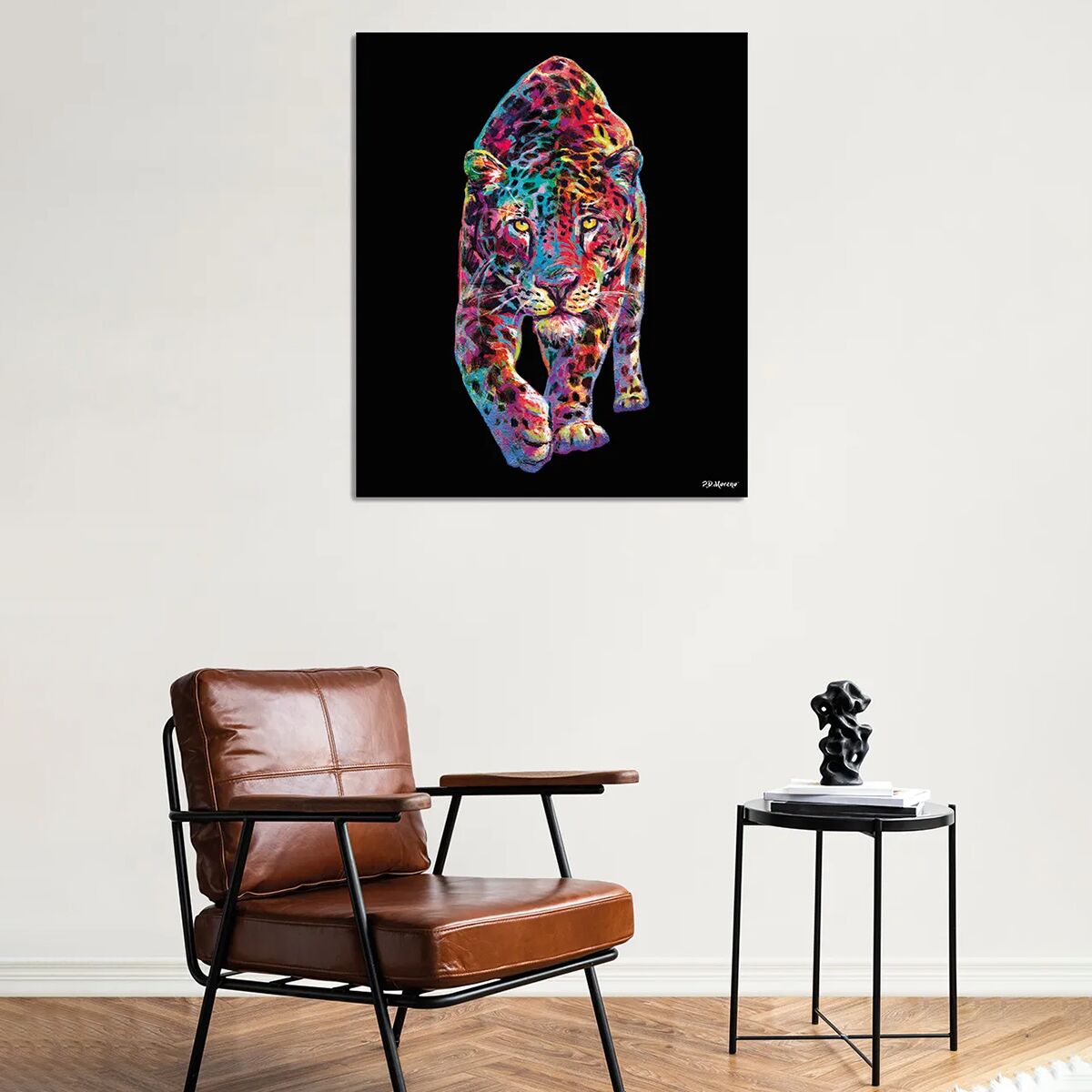 Großformatiger Kunstdruck mit einem farbenfroh gestalteten Leoparden auf schwarzem Hintergrund, gerahmt und hinter Acrylglas. Der Panther ist in lebhaften, kontrastreichen Farben dargestellt. Der Druck hängt über einem modernen Sessel und einem Beistelltisch in einem stilvoll eingerichteten Wohnzimmer.