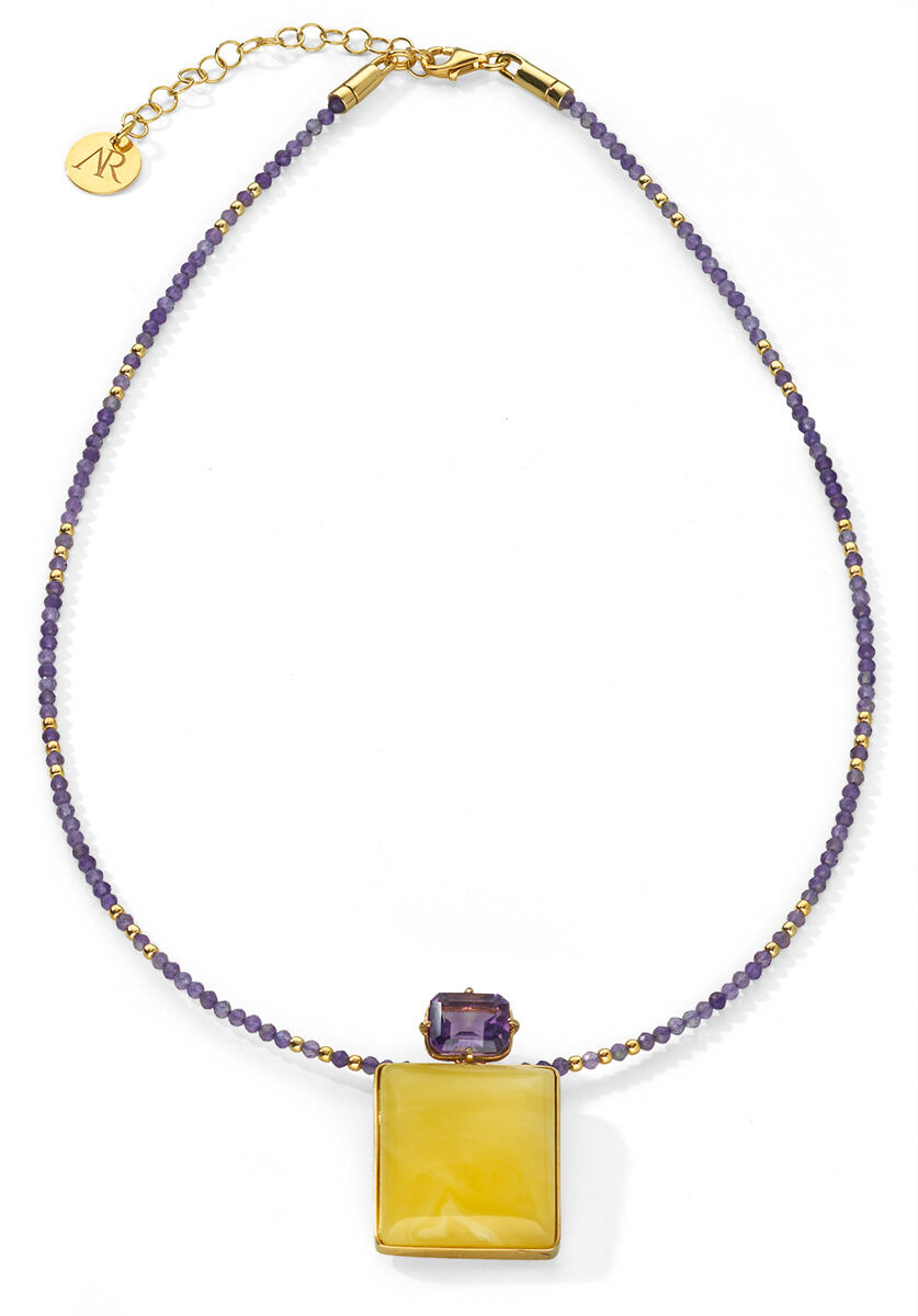 Bernsteincollier »Violetta« mit einem quadratischen Bernsteinanhänger und einem tropfenförmigen Amethysten in der Mitte. Die Kette besteht aus kleinen violetten und goldfarbenen Perlen, die abwechselnd angeordnet sind.