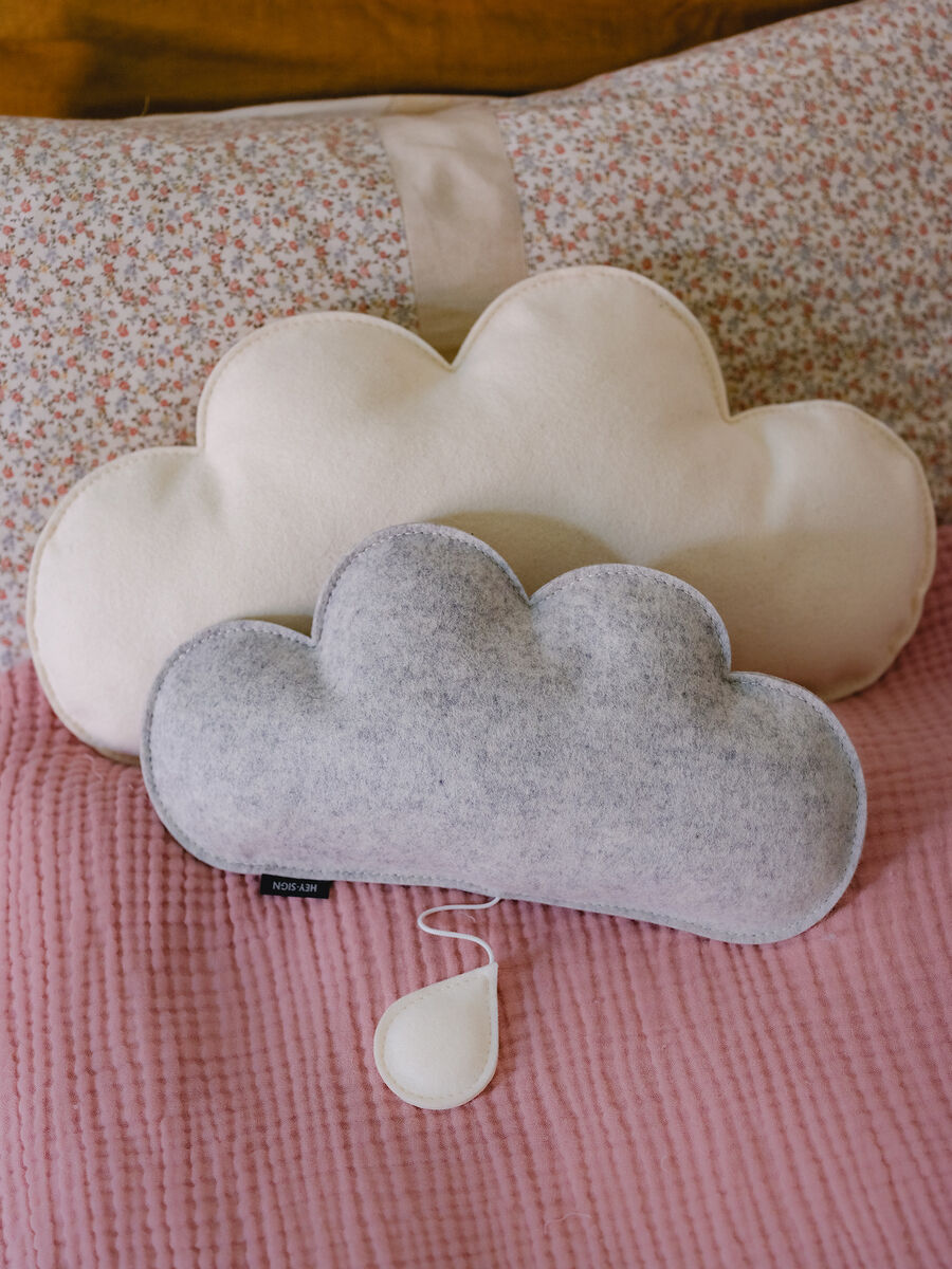 Spieluhr in Form einer Wolke in Grau und Weiß vor einem rosa Hintergrund, ideal für Baby- und Kinderzimmer, als Einschlafhilfe oder Geschenk.