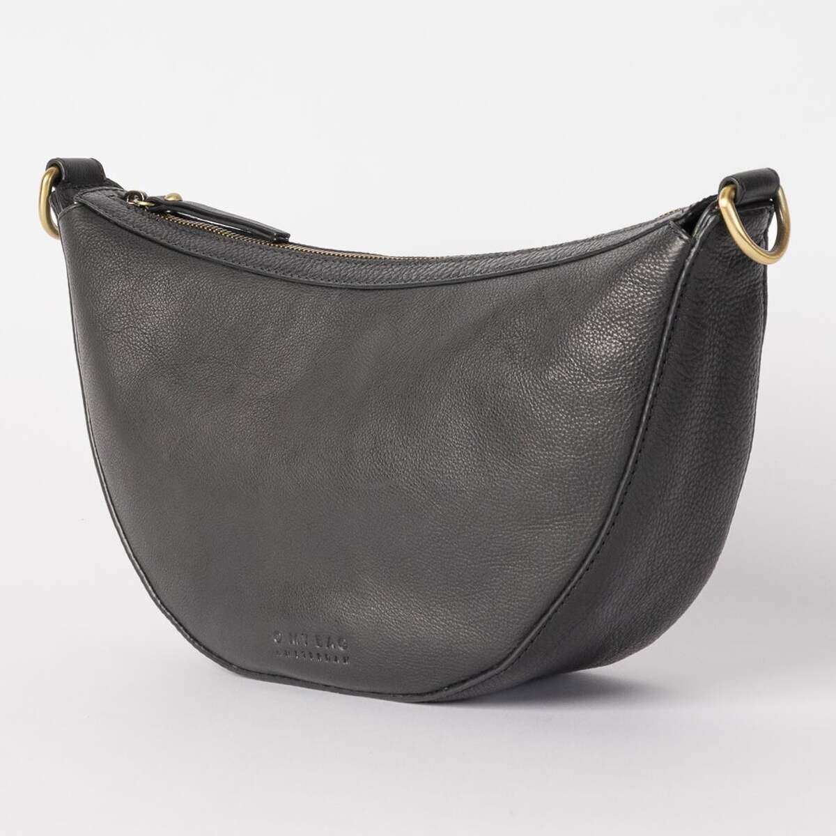 Die Abbildung zeigt eine dunkelgraue Umhängetasche in Halbmond-Form mit goldfarbenen Metallringen und einem Reißverschluss, präsentiert vor neutralem, hellem Hintergrund. Die strukturierte Lederoptik der Tasche wirkt modern und elegant.