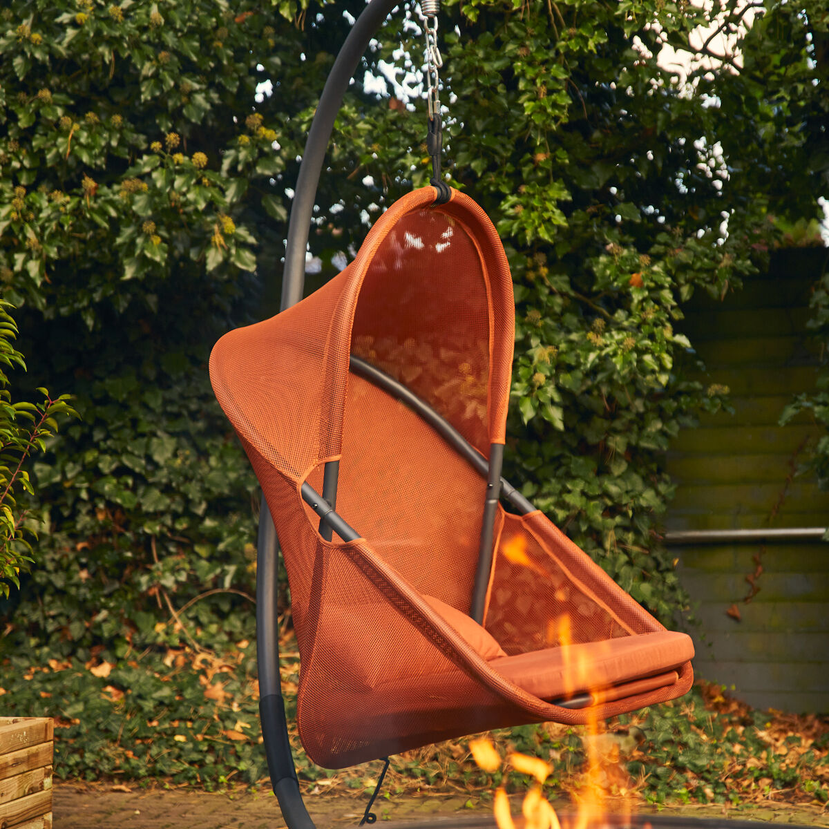 Detailreicher Hängesessel »Yobaya« von Sienagarden, freistehend auf hellem Untergrund. Das pulverbeschichtete schwarze Stahlgestell trägt einen luftigen, formschönen Korb aus offenporigem, rotem AIR MESH Polyester. Der Sessel wirkt modern, stabil und lädt durch seine großzügige Größe zum Entspannen ein.