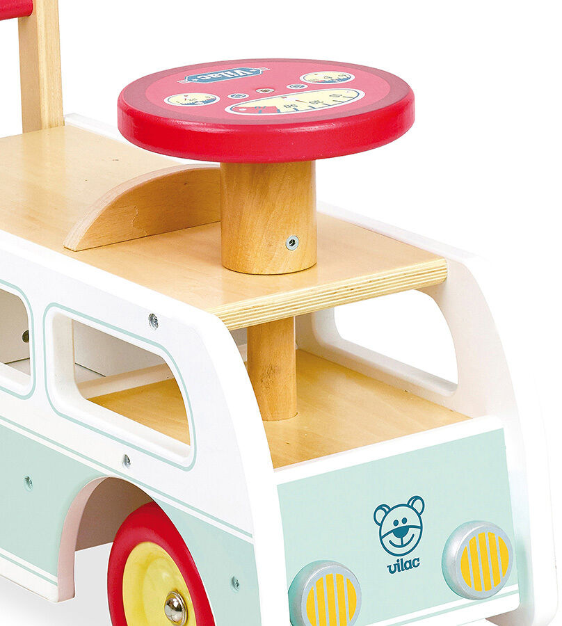 Ein Holzspielzeug in Form eines Minibusses mit weißer Karosserie, roten Rädern und Holzdetails. Das Fahrzeug hat bunte Details und ist für kleine Kinder geeignet, um zu schieben oder zu ziehen.