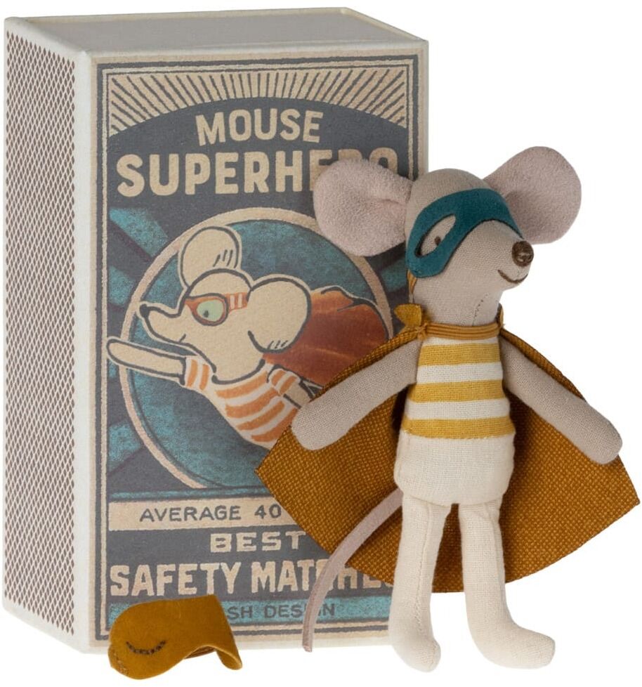Eine kleine Stoffmaus in einem Superhelden-Kostüm, bestehend aus einer gelben Streifenweste, einer blauen Maske und einem orangenen Umhang, steht vor einer Streichholzschachtel. Die Streichholzschachtel hat ein Retro-Design und ist mit einer Illustration der Superheldmaus verziert.