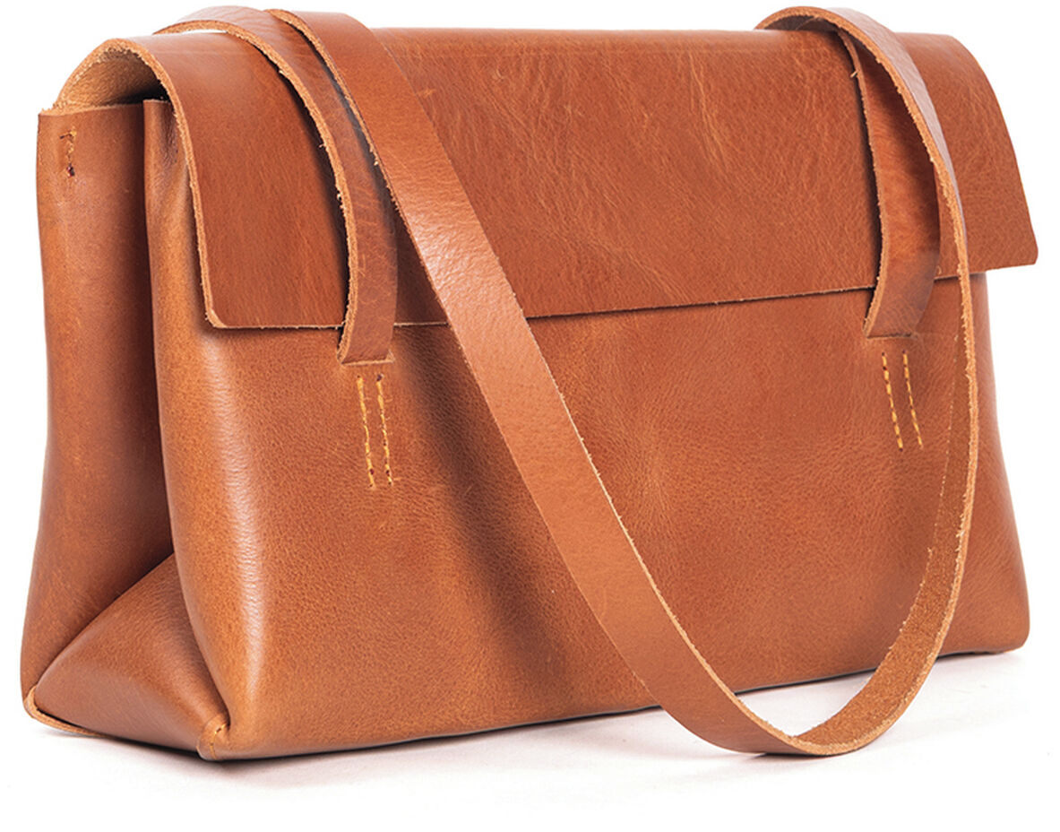 Eine elegante Schultertasche aus cognacfarbenem Kernleder der Marke Harold's Lederwaren steht im Fokus. Die Tasche hat eine schlichte Form, lange Träger und eine breite Umschlagklappe. Das Leder zeigt feine Maserung. Moderne Optik, hochwertige Verarbeitung, ideal für Frauen im Alltag.