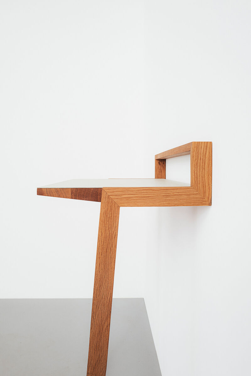 Ein modernes, minimalistisches Stehpult namens »buckowski«, aus Holz gefertigt. Das Pult ist an eine Wand montiert und verfügt über eine schlanke, platzsparende Konstruktion. Ideal für Home Office und kreative Arbeitsplätze.