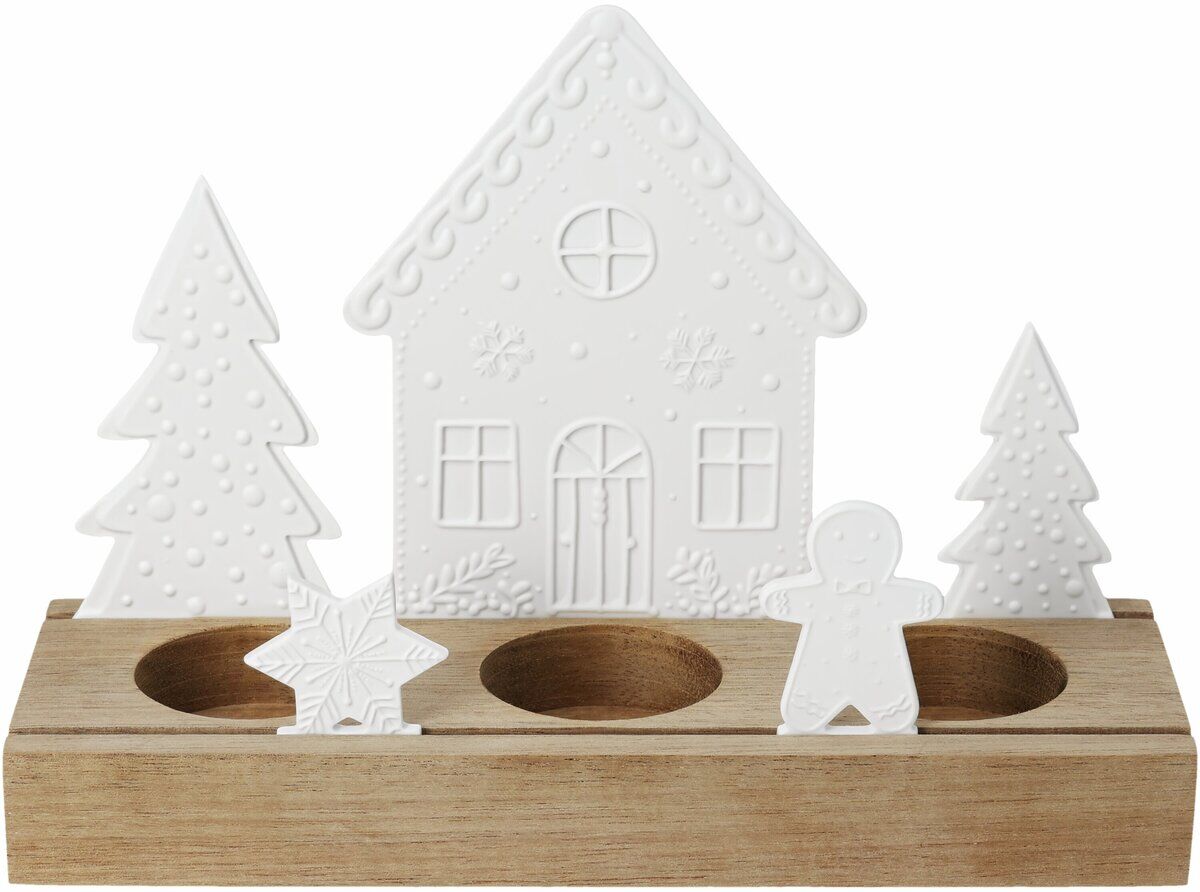 Das Bild zeigt das Lichtobjekt »Lebkuchendorf«, bestehend aus einem naturfarbenen Holzsockel mit drei runden Aussparungen, verziert mit weißen Silhouetten: einem Lebkuchenhaus, zwei Tannenbäumen, einem Stern und einem Lebkuchenmann. Die Oberflächen sind fein strukturiert.