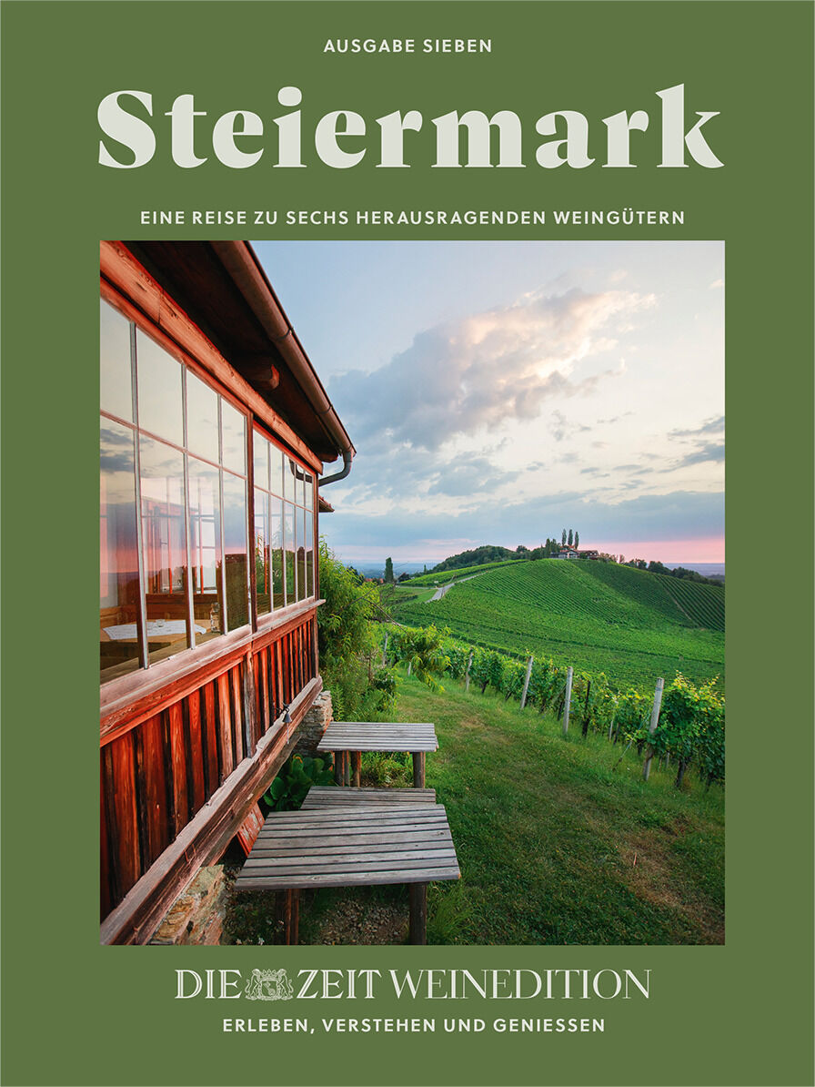 Buchcover der ZEIT-Weinedition »Steiermark«, zeigt eine idyllische Landschaft mit Hügeln, Weinbergen und einem Holzhaus im Sonnenuntergang. Im Hintergrund ist ein weiter Ausblick auf die hügelige Umgebung zu sehen.