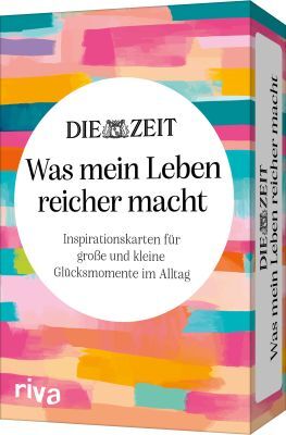 Abgebildet ist eine rechteckige Schachtel mit dem Titel des Kartenspiels „Was mein Leben reicher macht“ von DIE ZEIT, gestaltet mit bunten horizontalen Pinselstrichen in Pink, Türkis, Gelb und Orange. In der Mitte befindet sich ein weißer Kreis mit schwarzer Schrift. Die Verpackung wirkt fröhlich und einladend.