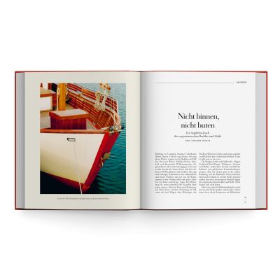 Aufgeschlagenes hochwertiges Hardcoverbuch der ZEIT-Edition »Hin und weg! 77 Lieblingsorte in Deutschland«. Linke Seite mit großformatigem Farbfoto eines Bootes am Steg, umgeben von blaugrünem Wasser und Sonnenlicht. Rechte Seite mit elegant gestaltetem Textbeginn und großzügigem Weißraum.