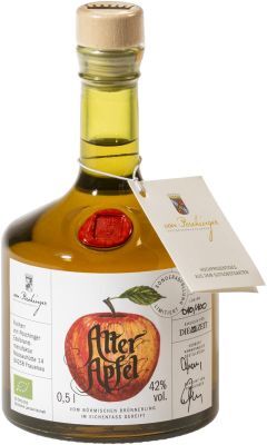 Flasche ZEIT-Sonderedition »Alter Apfel« Edelbrand mit einem beigefarbenen Korkverschluss, Etikett mit rotem Apfelmuster, grünen und goldenen Tönen.